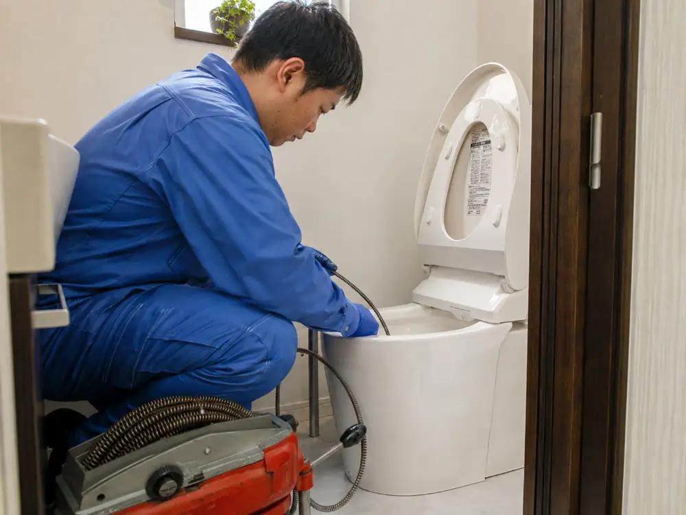 トイレの詰まりをワイヤーで除去する作業の様子